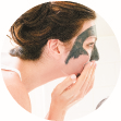 Female applying a mud mask to her face